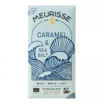A Meurisse milk chocolate wrapper shows rich brown and gold accents; an unwrapped bar reveals glossy milk chocolate squares with a ribbon of golden caramel between pieces and scattered pale sea-salt flakes catching the light.