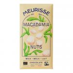A Meurisse milk chocolate bar sits unwrapped on a pale surface, its glossy surface divided into neat squares; creamy brown chocolate is studded with whole and halved macadamia nuts that protrude from each square. A branded wrapper lies nearby showing a warm, glossy logo. Soft sheen highlights glossy