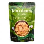 A cluster of twelve Kin + Deum Coconut Rice Chips 60 g bags sits against a white background. Each white-and-teal packet shows the Kin + Deum logo, coconut imagery and chip illustrations, with one open bag spilling pale, ridged rice crisps.