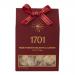 Bright rectangular box displays rose-pink Turkish delight and honey-golden almond nougat through a clear window. Floral motifs and delicate script adorn the lid. Inside, sugared cubes and marbled nougat pieces sit nestled in individual trays, showing soft, powdery and glossy textures. With gold trim.