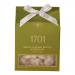 A compact rectangular box labeled Salted Caramel Brittle and Pistachio Honey Nougat features warm caramel tones and pistachio-green accents. A clear window reveals glossy amber caramel shards and creamy nougat studded with green pistachio pieces against a clean white backdrop.