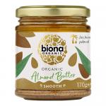 Six identical Biona Organic Almond Butter Smooth jars sit in a neat group. Each clear jar reveals creamy light-brown almond butter and has a pale lid plus a white label with a green Biona logo and simple text. Soft lighting, neutral background.