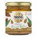 Six identical Biona Organic Almond Butter Smooth jars sit in a neat group. Each clear jar reveals creamy light-brown almond butter and has a pale lid plus a white label with a green Biona logo and simple text. Soft lighting, neutral background.