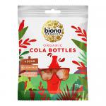 A clear plastic bag displays ten 75g Biona Organic Cool Cola bottle-shaped sweets, their translucent brown jelly and white caps visible through the wrap. The front label shows retro cola graphics, bold logo text and organic certification icons on a natural kraft-paper background. Soft gleam appears.