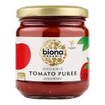Six identical 200g glass jars of Biona Organic Tomato Puree stand arranged in two neat rows. Each jar reveals deep-red puree through clear glass, a bright red label with the white Biona logo and product name, and a silver metal lid. Soft lighting highlights glossy tomato tones. Organic seal visible.
