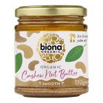 Six glass jars of Biona Organic Cashew Butter sit in neat rows. Smooth beige butter fills each jar beneath cream lids. Green-and-white labels show the Biona logo and product name. Soft studio light creates gentle highlights on glass and creamy texture.