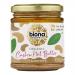 Six glass jars of Biona Organic Cashew Butter sit in neat rows. Smooth beige butter fills each jar beneath cream lids. Green-and-white labels show the Biona logo and product name. Soft studio light creates gentle highlights on glass and creamy texture.
