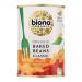 A line of metal cans shows Biona Organic Classic Baked Beans with green-and-white labels marked 400g, stacked on a shelf. The label features baked-bean imagery, organic certification and ingredient text. Soft lighting creates highlights and subtle reflections on curved tin surfaces. Nearby tags blur.