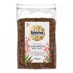 Image shows six 500g Biona Organic Camargue Red Rice packs arranged in two rows. Clear pouches reveal deep red-brown grains. White-and-green labels present the Biona logo, product name and organic certification symbols on a neutral light background. Under soft studio light, faint reflections appear.