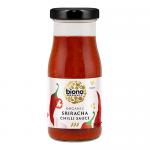 A set of six 130ml Biona Organic Sriracha bottles sits against a plain background. Vivid red sauce shows through clear bottles. Labels are white and green featuring the Biona logo and organic markings; each bottle is topped with a white screw cap.