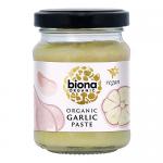A clear glass jar of Biona Organic Garlic Paste displays pale, creamy paste beneath a green screw lid. The label shows the Biona logo, hand-drawn garlic bulbs and green-and-white typography, presenting a simple, natural visual with clean lines and soft colors.