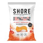 Image shows a Shore Seaweed Chips - Sweet Sriracha packet. A red-orange pouch bears the Shore logo, green seaweed illustrations and scattered dark-green crisps. Prominent text displays Seaweed Chips and 80g. Glossy finish and studio lighting emphasize crisp texture. Subtle shadows add depth. Low rim.