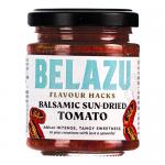 Six clear glass jars of Belazu Balsamic Sun Dried Tomato sit in a neat row. Each jar shows glossy, deep-red tomato pieces suspended in dark balsamic oil. Cream labels with black type and white lids contrast the vivid, chunky tomato texture against a neutral background. Soft highlights gleam on glass.