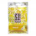 A stack of yellow Coco Cubes Banana wrappers rests on a light surface. Square coconut-and-banana pieces appear through small windows. Glossy packaging shows a brown logo, banana illustration and simple icons. Soft shadows and warm lighting create depth. Close-up shows coconut flakes and ripe banana.