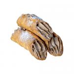 An open box reveals six golden-brown cannoli, each crisp shell piped with creamy salted-caramel filling that slightly oozes from the ends. A light dusting of powdered sugar flecks the shells while tiny caramel shards and glossy drips catch the light. The tray rests on rustic wood with crinkled paper
