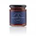 Six small glass jars sit aligned, filled with glossy deep-red strawberry conserve. Each jar wears a cream lid and a vintage-style label reading Annabel's Yorkshire Strawberry Conserve, featuring delicate botanical illustrations and gold trim on a warm cream backdrop.