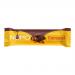 A glossy brown and caramel-toned wrapper with the NOMO logo sits centered. One bar lies partially unwrapped to reveal smooth milk chocolate and a visible caramel ribbon through a dense interior. Soft studio lighting casts mild highlights and a faint shadow on a neutral background. Soft glossy finish