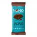 A matte, minimalist wrapper in deep brown and warm beige shows the NOMO logo in bold white. A partially unwrapped dark chocolate block sits beside it, revealing glossy caramel swirls and scattered flaky sea salt crystals on the surface, with a few crumbs on a light background.