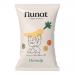 A bright bag of Nunat Parsnip Vegan Snack sits upright, cream-and-green packaging features a stylized parsnip illustration and bold Nunat logo. Nutritional icons and weight text appear; scattered golden parsnip crisps lie beside the bag on a light wooden surface soft natural light casts soft shadows