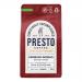 A row of six Presto Coffee Roasters Espresso Intenso 200g bags sits on a shelf. Matte black packaging features bold white and copper lettering, a minimalist logo and roast details. Uniform bags angle slightly, casting soft shadows against a neutral grocery aisle background. Fine print near the base.
