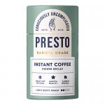 Several matte white jars of Presto Coffee Roasters House Decaf Instant Coffee sit grouped on a neutral surface. Simple black labels feature bold Presto text and a stylized coffee icon. Warm light creates soft shadows and highlights the powdery texture of the granules. A small spoon lies just nearby.