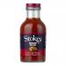 A row of six clear glass bottles stands, each filled with deep red-brown chunky relish. Cream labels encircle the midsection with a bold Stokes logo and product name, accented by simple graphics. Metal screw caps shine as light reflects on the glass surfaces. Neutral backdrop casts soft even shadows.