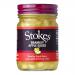 Six clear glass jars sit in a cardboard tray, each filled with pale golden Bramley apple sauce. Green-and-white labels wrap the jars with the Stokes name; silver lids catch the light. Jars stand closely together, revealing a smooth, slightly chunky fruit texture.