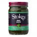 A neatly arranged set of six Stokes Mint Sauce jars sits on a neutral surface. Clear glass reveals bright green sauce. Cream-and-green labels feature the Stokes logo and simple typography. Metal lids catch highlights while soft shadows fall behind the uniform row. A soft label texture is visible....