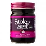 A clear glass jar shows glossy deep-red onion marmalade with visible onion strands. A cream paper label wraps the jar displaying a bold Stokes logo, small black text and simple illustrations. A metal screw lid seals the top and light reflects on the glass surface. Tiny bubbles cling beneath the lid.