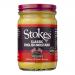 A cluster of glass jars labeled Stokes Classic English Mustard sits against a neutral background. Bright yellow mustard shows through clear glass; cream labels with a red Stokes logo and black text wrap each jar. Metal lids reflect soft studio lighting. They form two rows, labels slightly askew.