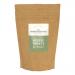 A sturdy 800g-sized kraft-style bag stands upright, showing a vintage crest logo with a mustachioed dog illustration, bold typography reading the brand name, a clear panel revealing bite-sized brown treats, and blue accents with feeding icons and minimalist product details Soft light and a pale studio backdrop