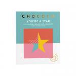 A photo shows twelve 75g Chococo milk chocolate bars in a neat pack, each glossy wrapper featuring the Chococo logo, “You’re a Star” lettering and a star motif with “47%” cocoa marked. Warm brown and gold tones gleam under soft lighting, edges and textures clearly visible. Soft shadows add depth...