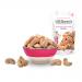 A neat arrangement of Mr Filberts-branded pouches sits against a plain backdrop. Bright yellow and red labels display the logo and an appetizing close-up of glazed cashews. One pouch lies open with glossy, golden-brown cashews spilling onto the surface, showing salt crystals. Soft shadows add depth.