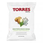 A bright green and cream bag sits upright, showing golden, round crisps scattered beside sprigs of rosemary and oregano. The label shows Mediterranean coastal illustrations, fresh herb graphics, and the brand name across the top.