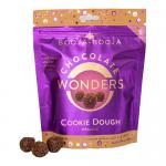 A neatly opened box reveals eight bite-sized round chocolates, their glossy dark-brown shells slightly dusted with cocoa. Each sits in an individual recess. The box art combines cream and chocolate tones with simple logo lettering and a small illustration suggesting a cookie dough centre. Soft sheen