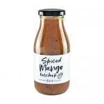 Six identical bottles stand in a neat row, each filled with glossy orange-red spiced mango ketchup. Bright yellow-orange labels wrap the midriff with bold Hawkshead Relish text and a minimalist graphic; black screw caps top clear glass that reflects soft studio light Subtle shadows pool behind them