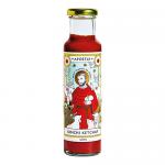 Label shows a reverent depiction of Saint Francis of Assisi in earthy tones, haloed and gentle, surrounded by chilies and cabbage motifs. A tall glass bottle of kimchi ketchup displays a red-orange condiment, simple typography and a rustic grocery logo against a cream backdrop. Soft light on the glass
