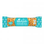A dozen slim, brown-and-cream wrapped bars bearing the Joe & Seph’s logo sit in neat rows. One bar is unwrapped to reveal glossy salted caramel-coated popcorn studded with chopped nuts, with a few loose kernels and nut fragments scattered on a white background.