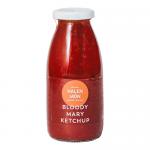 A glass bottle of Halen Môn Bloody Mary Ketchup sits against a neutral backdrop. Deep red sauce shows through, labeled with nautical motifs and Anglesey sea salt wording. Festive holly accents and a subtle cranberries illustration add seasonal charm to the packaging. A silver cap and scattered salt.