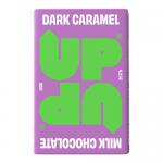 Glossy deep-brown wrappers in a neat ten-bar pack surround a matte box stamped with the bold UP-UP logo. Dark chocolate squares gleam beside ribbons of golden caramel, with subtle gold trim and nutritional text at the back. Lighting highlights the sheen and textured chocolate surface. Close-up focus.
