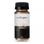 Twelve 45g jars of Truffle Guys Signature Truffle Dust sit in neat rows; each clear glass jar shows fine dark-brown powder and wears a black lid with a red, festive label bearing white script. Soft holiday props and warm lighting frame the cluster on a rustic wooden surface. snow-dusted pine sprigs.