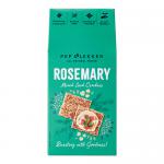 Brown paper packet with green accents displays a clear window showing thin, golden-brown rosemary crackers studded with mixed seeds. The crisp edges, visible herb flecks and scattered sesame, flax and sunflower seeds create a rustic, artisanal appearance. Natural uneven browning and tiny air pockets.