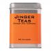 A boxed Jinger Drinks ginger and turmeric tea sits amid a festive Christmas scene. Bright red and gold packaging displays ginger root and turmeric slices. A steaming cup and loose tea bags rest nearby, surrounded by pine sprigs, cinnamon sticks and soft falling snowflakes. Warm glow accents details.