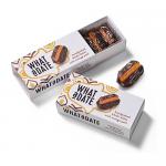 Twelve 50g What a Date Orange Peel snack packs sit together in the image. Wrappers use bright orange, festive Christmas motifs and peel illustrations; small clear windows reveal glossy strips of candied orange peel.