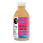 Six 200ml NOJO Tahini Noodle Sauce bottles stand in a row, creamy beige sauce visible through clear glass. White labels show bold NOJO lettering, a tahini illustration and ingredient icons. Metal caps and soft studio light cast faint shadows.