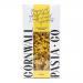 A nest of golden saffron mafalda ribbons sits beside Cornwall Pasta Co packaging. The organic-labelled box features festive Christmas motifs—holly sprigs, gold accents and stars— and is set on a rustic wooden board with warm, soft lighting.