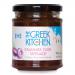 A clear glass jar of The Greek Kitchen Kalamata olive tapenade (180g) sits upright, revealing deep purple-black, coarse olive paste. The label shows the brand and product name; a silver lid caps the jar against a plain background.