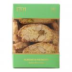 An elegant rectangular box shows a neat row of golden-brown biscottini through a clear window, each crisp slice speckled with toasted almonds and bright green pistachio pieces. Crumbly texture, light sugar dusting and simple label rest against a warm, neutral backdrop. soft shadows accent warm tones