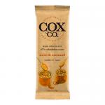 A small rectangular chocolate bar rests on a neutral surface in cream-and-caramel packaging bearing the Cox&Co. logo and bold type. One bar is unwrapped, revealing glossy dark chocolate squares topped with tiny caramelized flakes.