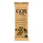 A neat arrangement of individually wrapped Cox&Co. 60% Bee Pollen & Honey chocolate bars sits on a neutral background. Dark chocolate squares show amber bee-pollen specks and a glossy sheen; one unwrapped bar reveals textured pieces and a honey-toned crumb.